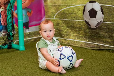 Gustavo segurando uma bola de futebol enquanto brinca no espaço infantil do Rafa Eventos, em Tatuí SP.'
