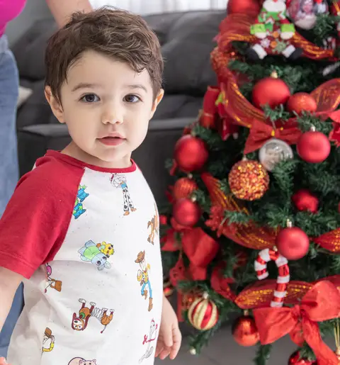 Fotografia de família com criança perto da árvore de natal'