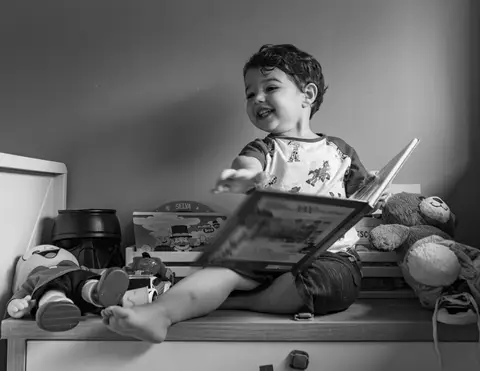 Fotografia de família com criança com livro'