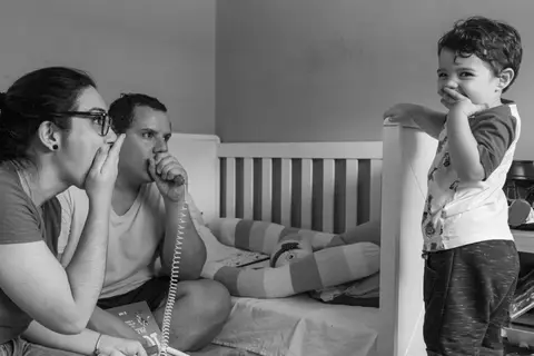 Fotografia de família com criança brincando com os pais'