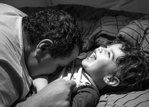 Fotografia de família com criança brincando com o pai'