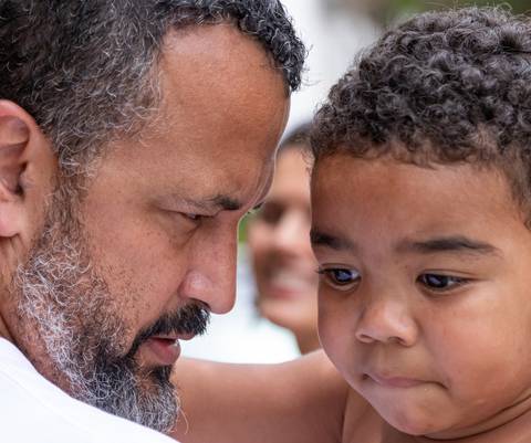 Fotografia de família com criança abraçada com o pai'