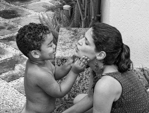 Fotografia de família com criança fazendo carinh na mãe'