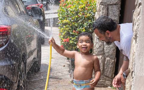 Fotografia de família com criança brincando com água'