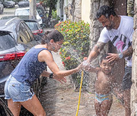Fotografia de família com criança brincando com água'