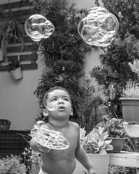 Fotografia de família com criança com bolhas de sabão'