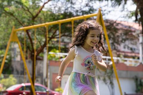 Fotografia de família com criança correndo na praça'
