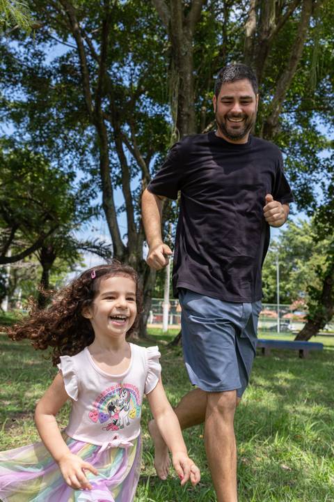 Fotografia de família com criança correndo com o pai'