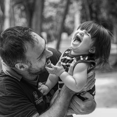 Fotografia de família com pai e filho brincando'