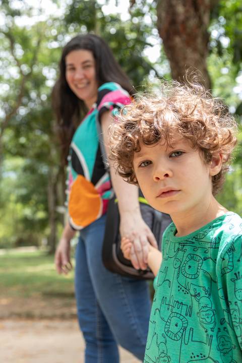 Fotografia de família com menino segurando a mão da mãe'