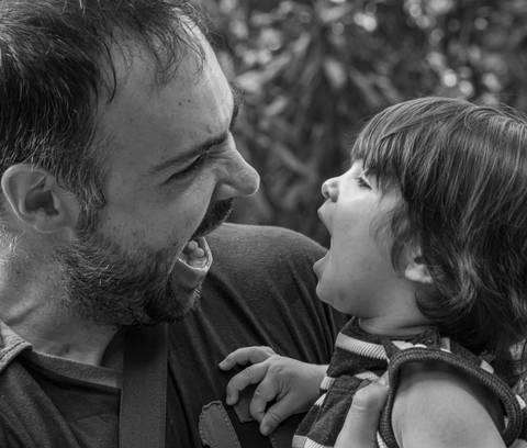 Fotografia de família com pais e filho fazendo careta'