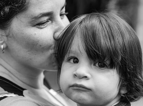 Fotografia de família com mãe beijando a cabeça do filho'