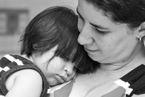 Fotografia de família com criança dormindo no colo da mãe'