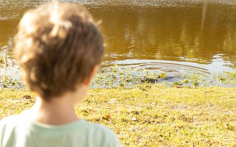 Fotografia de família com menino olhando pata o jacaré'