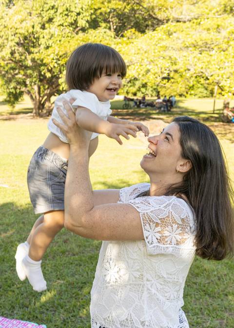 Fotografia de família com mãe levantando o filho nos braços'
