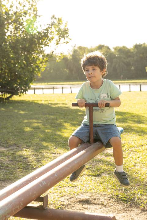 Fotografia de família com menino na gangorra'