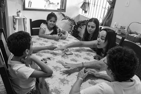 Fotografia de família conversando à mesa'