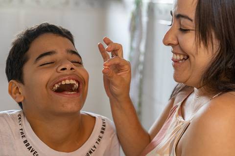 Fotografia de família com mãe extraindo dente do filho'