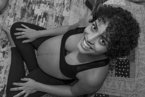 Fotografia de família com gestante olhando pra cima e sorrindo'