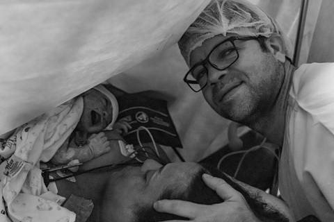 Fotografia de família com pais e bebê na maternidade'