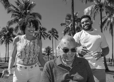 Fotografia de família com pai e filhos sorrindo'