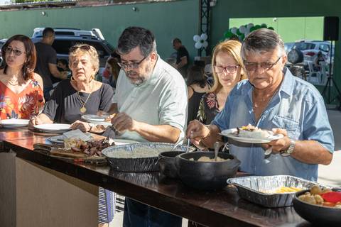 Fotografia de evento com pessoas servindo almoço'