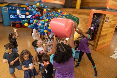fotografia de evento com crianças brincando de pegar olinhas coloridas'
