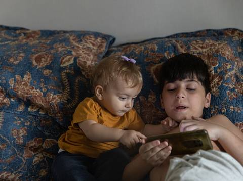 irmãos brincando na cama'