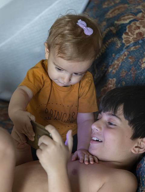 irmãos brincando na cama'
