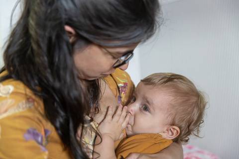 mãe amamentando sua filha'