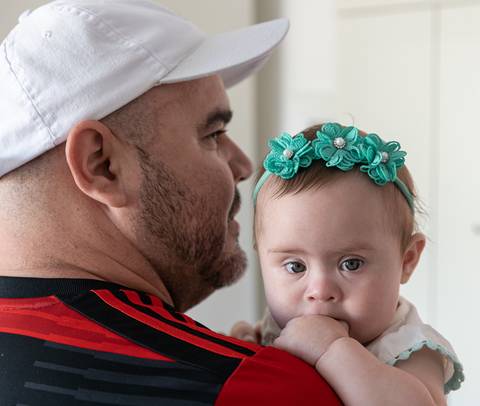 bebê com síndrome de down no colo do pai'