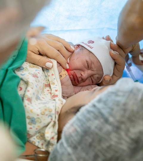 criança fazendo beicinho no colo da mãe'