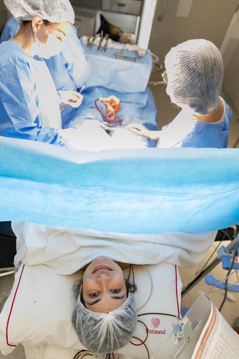 mulher sorrindo por ter acabado de dar à luz'