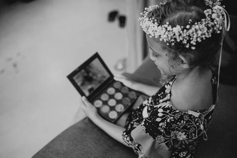 filha da noiva olhando para espelho da maquiagem'