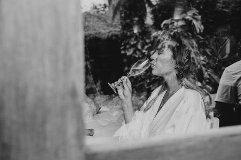 noiva sendo fotografada enquanto bebe champanhe '