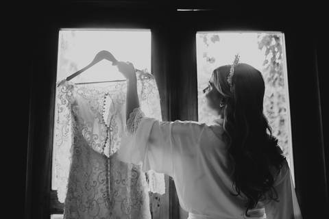 noiva segurando cabide com vestido'