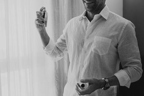 noiva passando perfume enquanto sorri'