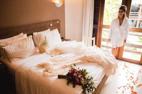 noiva olhando para vestido que está sob a cama
'