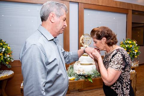 noiva beijando a mão da noivo após troca de aliança bodas de ouro'