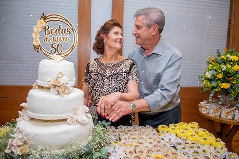 casal contando bolo bodas de ouro'