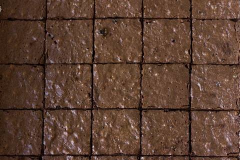 Brownie de Chocolate feito com ovos, farinha de coco, óleo de coco banana, passas, farinha de chia, açúcar mascavo, canela, e chocolate em pó'