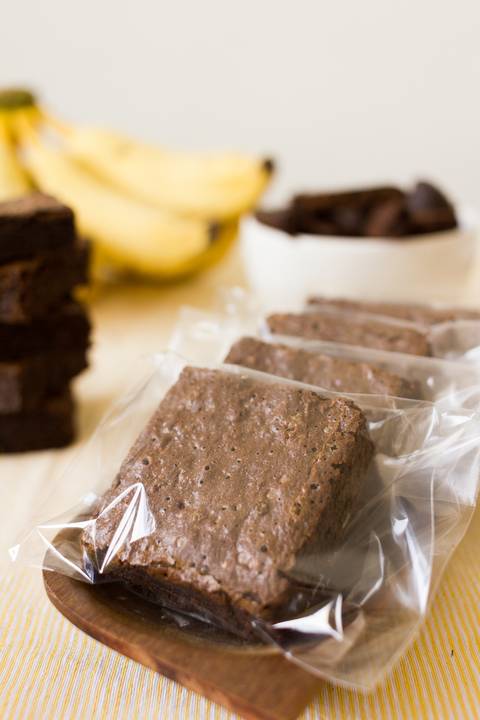 Brownie de banana com chocolate embalados e fotografados para um anuncio na internet em um cenário de fotografia de gastronomia rustico e feito de maneira profissional e unica para a marca brownana'