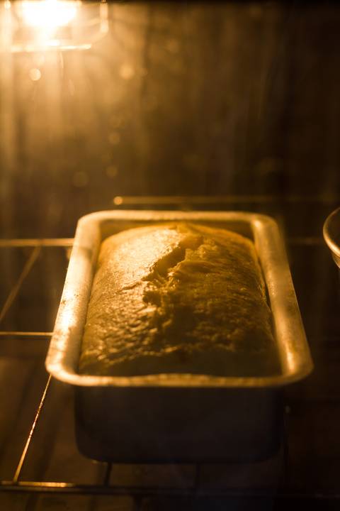 assadeira de alumínio no forno onde vemos um bolo sendo assado'