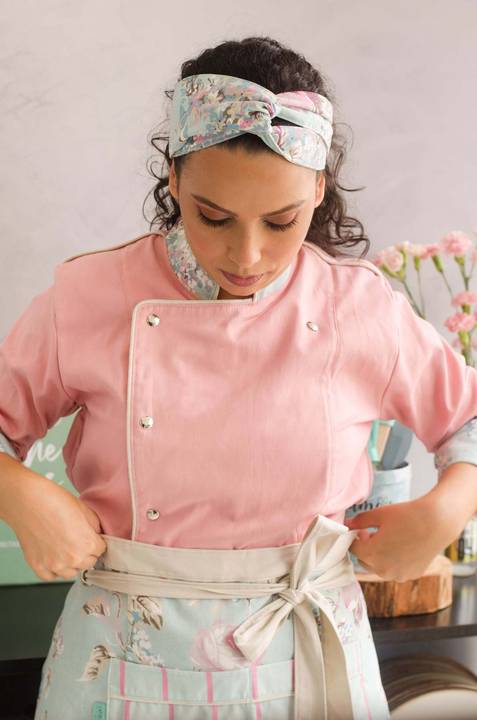 Chef confeiteira amarrando o avental na cintura '