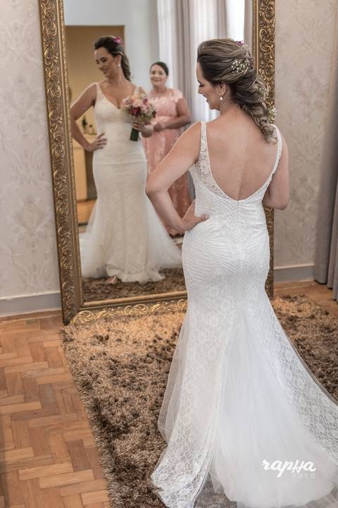 Fotografia tirada pelo fotógrafo de casamentos em BH, da noiva já pronta, momentos antes do casamento. Enfoque principalmente no vestido e conjunto completo com maquiagem.'