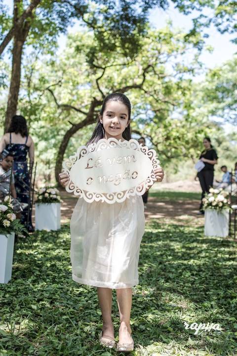 Fotografia tirada pelo fotógrafo de casamentos em BH, da daminha anunciando a chegada do noivo em close.'