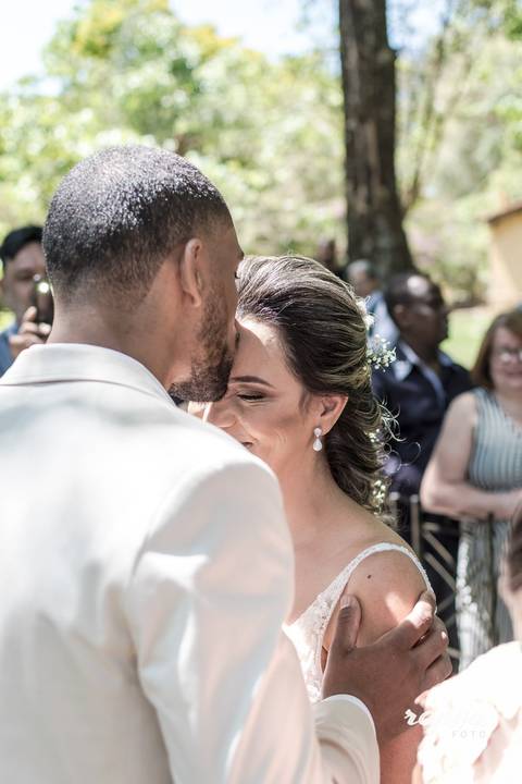 Noivo beija sua noiva na testa na chegada da noiva ao casamento.'