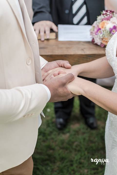 Rapha Drummond fotografa noivos de mão dadas em foco.'