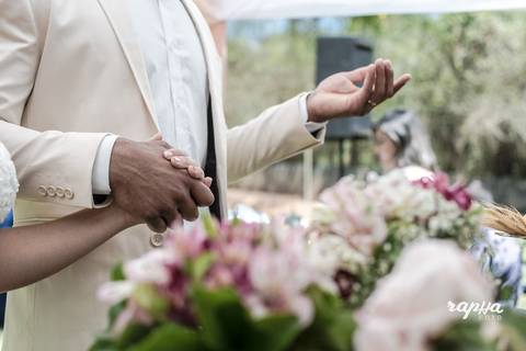 Fotografia dos noivos de mãos dadas em oração registrada pelo fotógrafo Rapha Drummond, especialista em casamentos.'