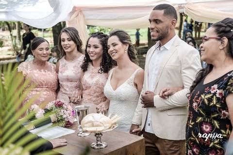 Foto da família dos noivos no altar recebendo as bençãos no casamento registrado pelo fotográfo Rapha Drummond.'